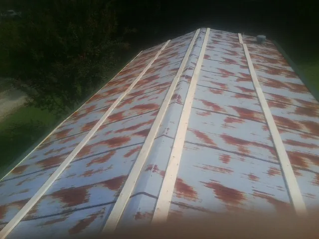 Rusted metal roof panels with new wood purlins before replacement — Storm Damage Roof Repair in Tie Siding by Roofing Brothers