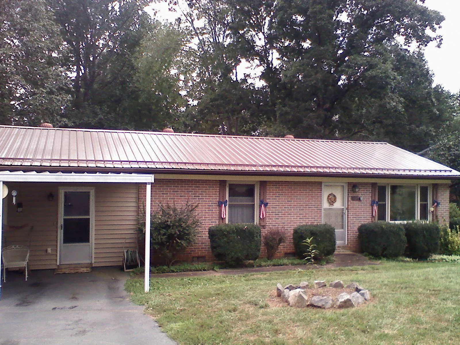 Bronze metal roof and carport on a brick ranch home — Roof Repair work by our crew in Tie Siding