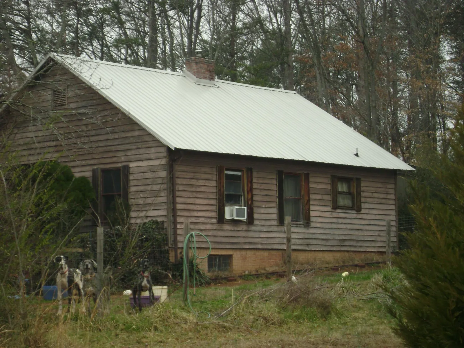 White metal roof on an old wood sided farmhouse, from a Metal Roof Installation job in Tie Siding